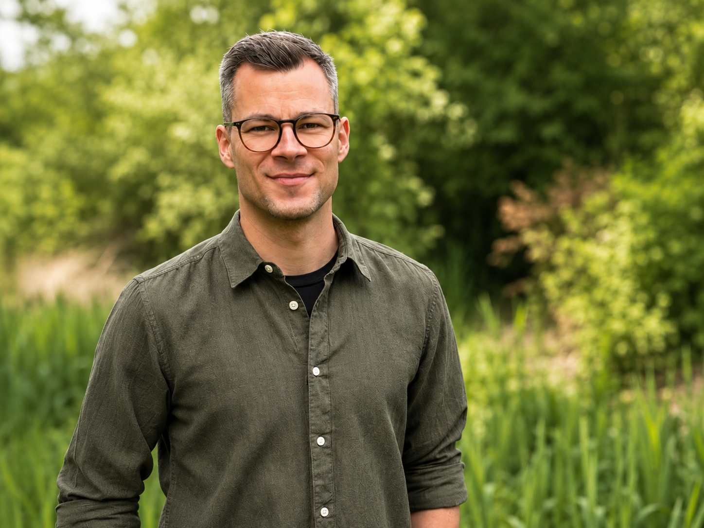 Ronny Sommerschuh steht in grüner Umgebung und blickt freundlich in die Kamera.
