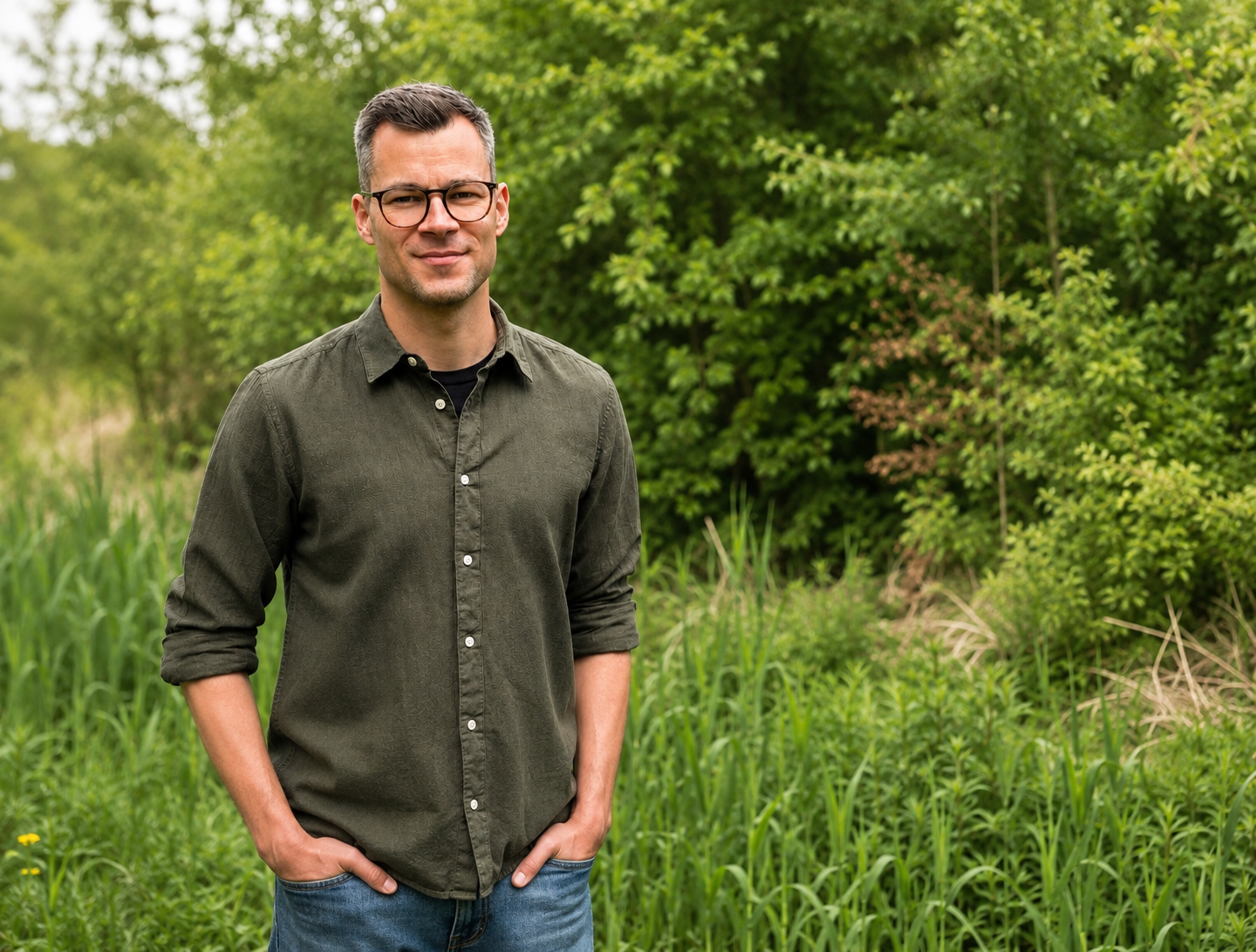 Porträt von Ronny Sommerschuh in grüner Umgebung.